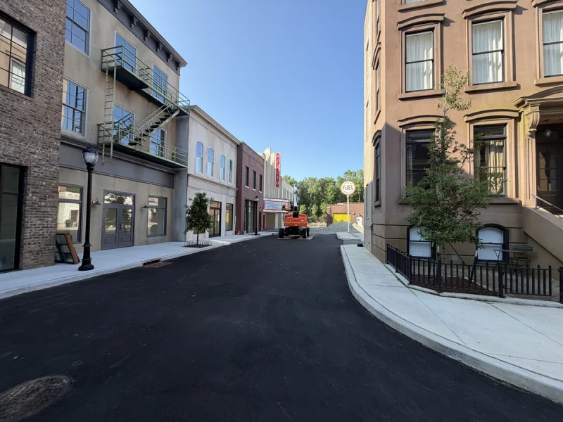 Painted storefronts and a historic corner building along the completed mixed-use street