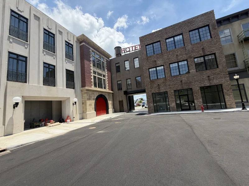 Courtyard elevation combining a bright painted facade with adjoining brick buildings