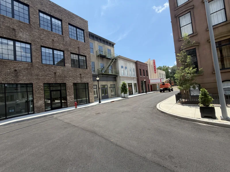 Brick courtyard building with dark framed storefront windows and finished exterior trim