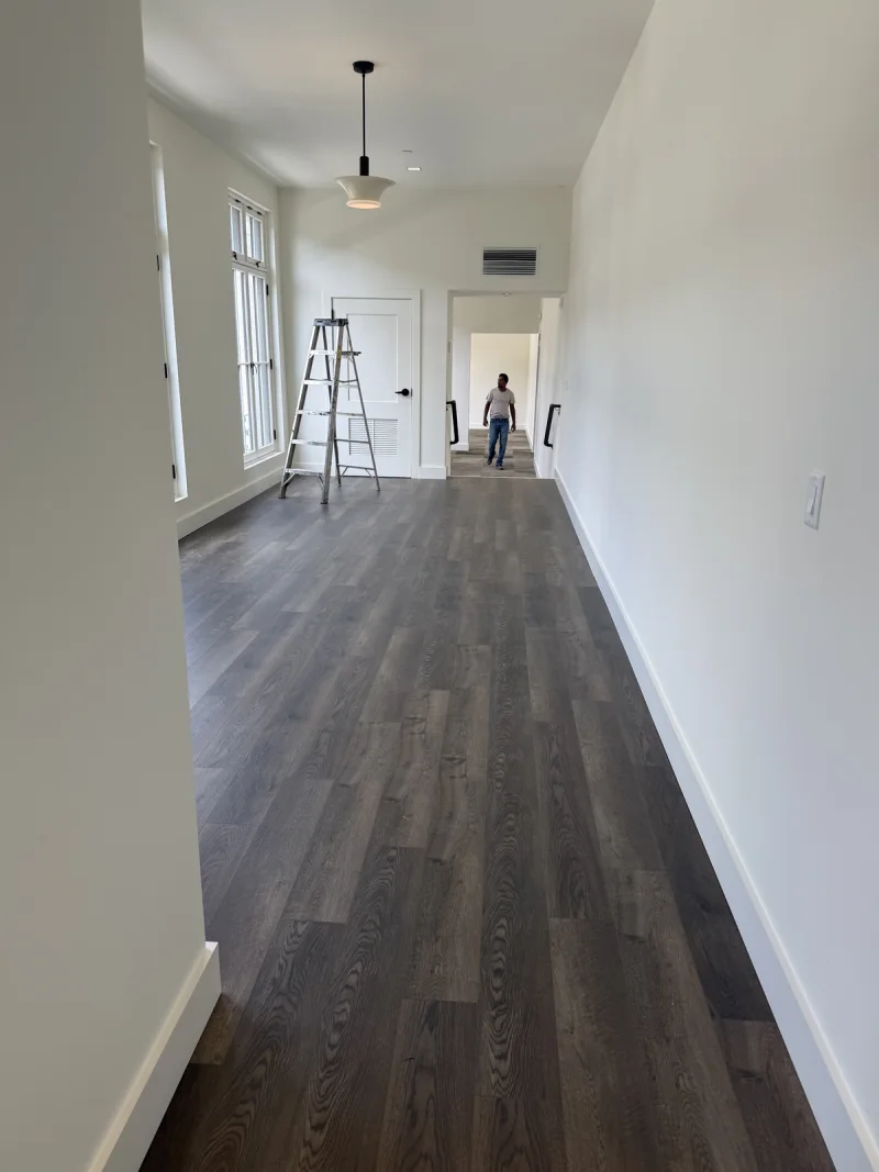 Interior corridor mid-finish, with a step ladder set up beside newly painted walls